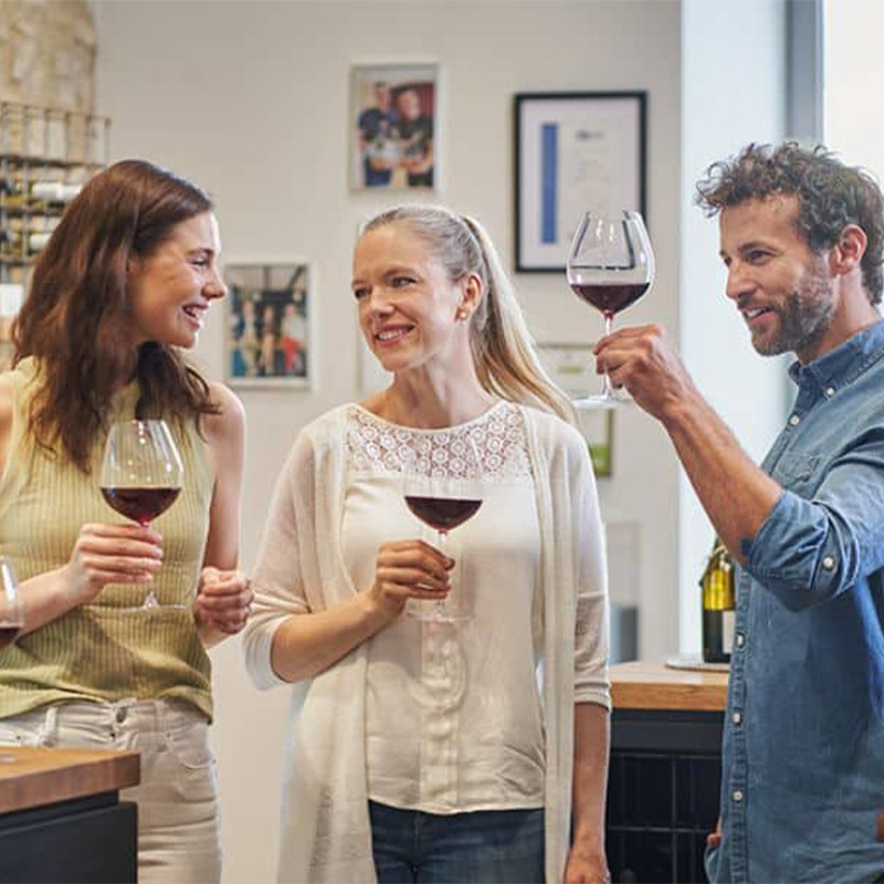 3 Personen bei einer Weinprobe in der Vinothek